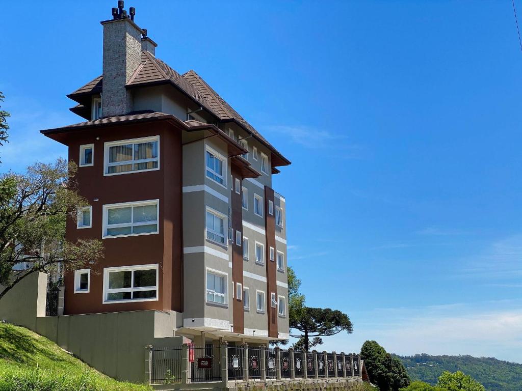 ein Gebäude mit einem Turm auf einem Hügel in der Unterkunft Apartamentos Residencial Villa Rossa by Achei Gramado in Gramado