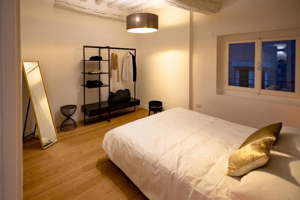 BF Glam-Apartments في بيروجيا: غرفة نوم بسرير ابيض ومرآة
