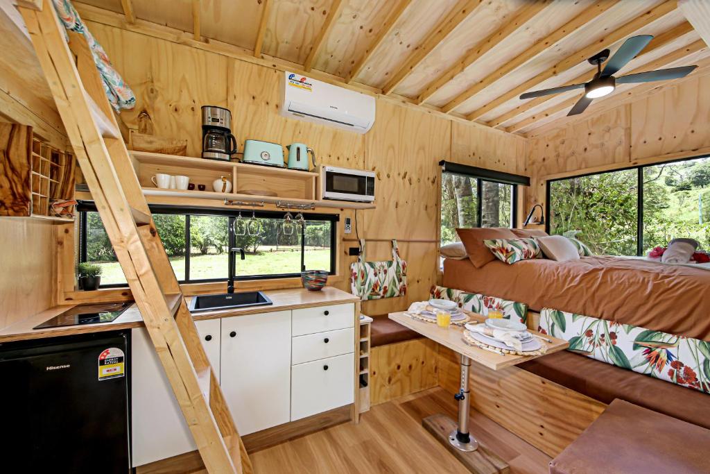 a tiny house with a kitchen and a bunk bed at Holiday with Nature in Cooran
