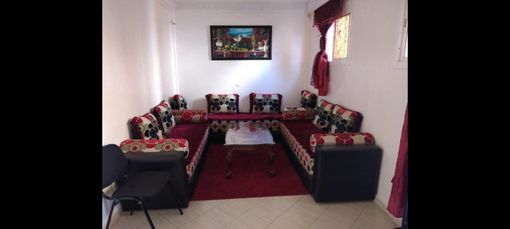 uma sala de estar com sofás, uma mesa e cadeiras em Appartement meublé près du grand souk Elhad em Agadir