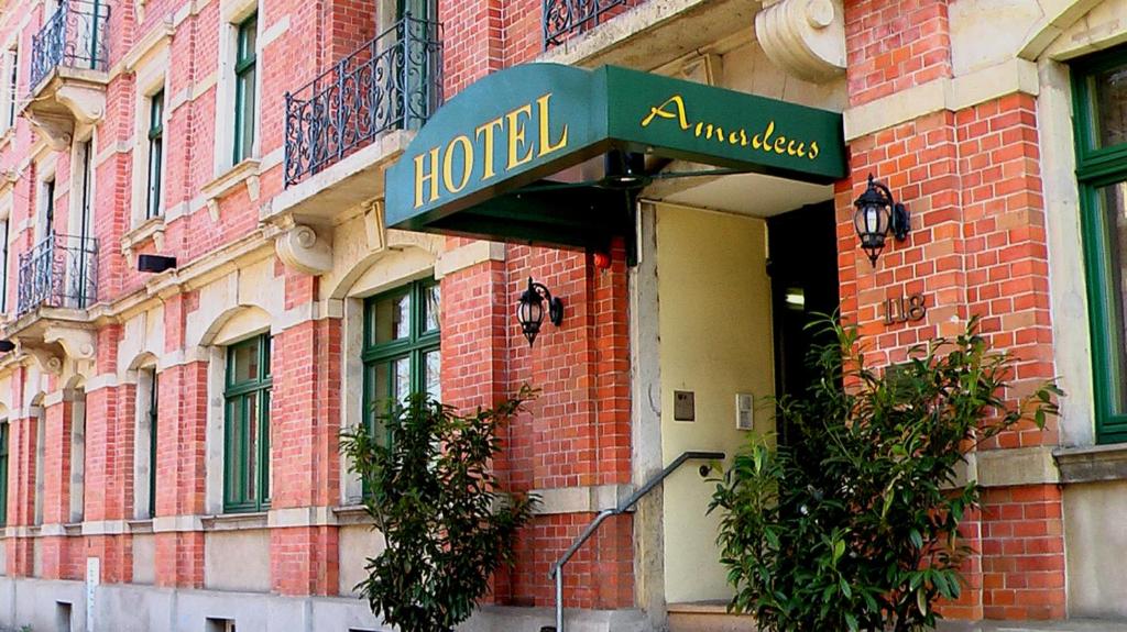 un panneau d'hôtel sur le côté d'un bâtiment en briques dans l'établissement Hotel Amadeus Dresden Neustadt, à Dresde