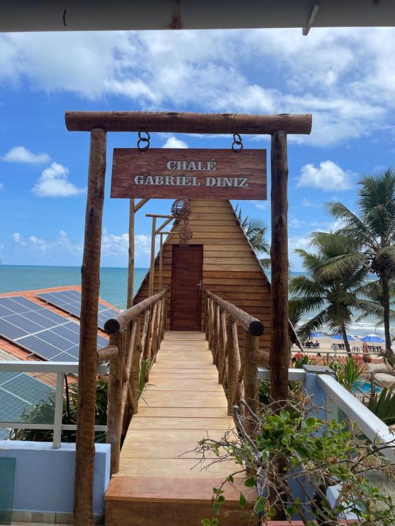 a wooden boardwalk leading to a chapel at the beach at Pousada Beach House Coqueirinho in Jacumã