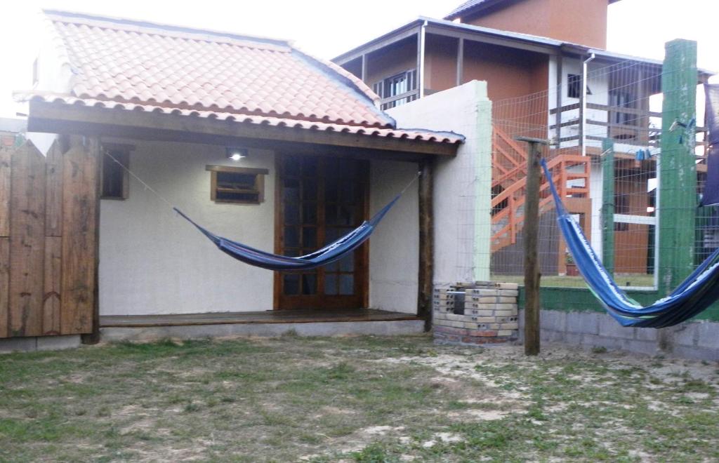 two blue hammocks hanging from the side of a house at ICE POINT SURF HOUSES Praia do Rosa- Necessário Pré-pagamento Metade Valor Total in Praia do Rosa