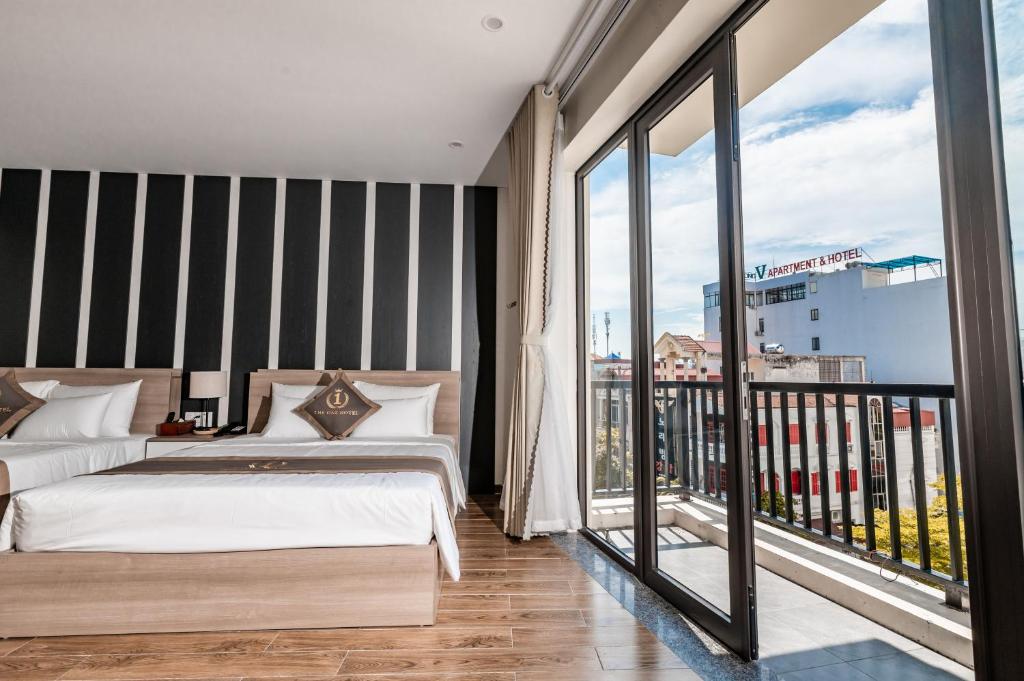 een slaapkamer met 2 bedden en een balkon bij The One Hotel in Hai Phong