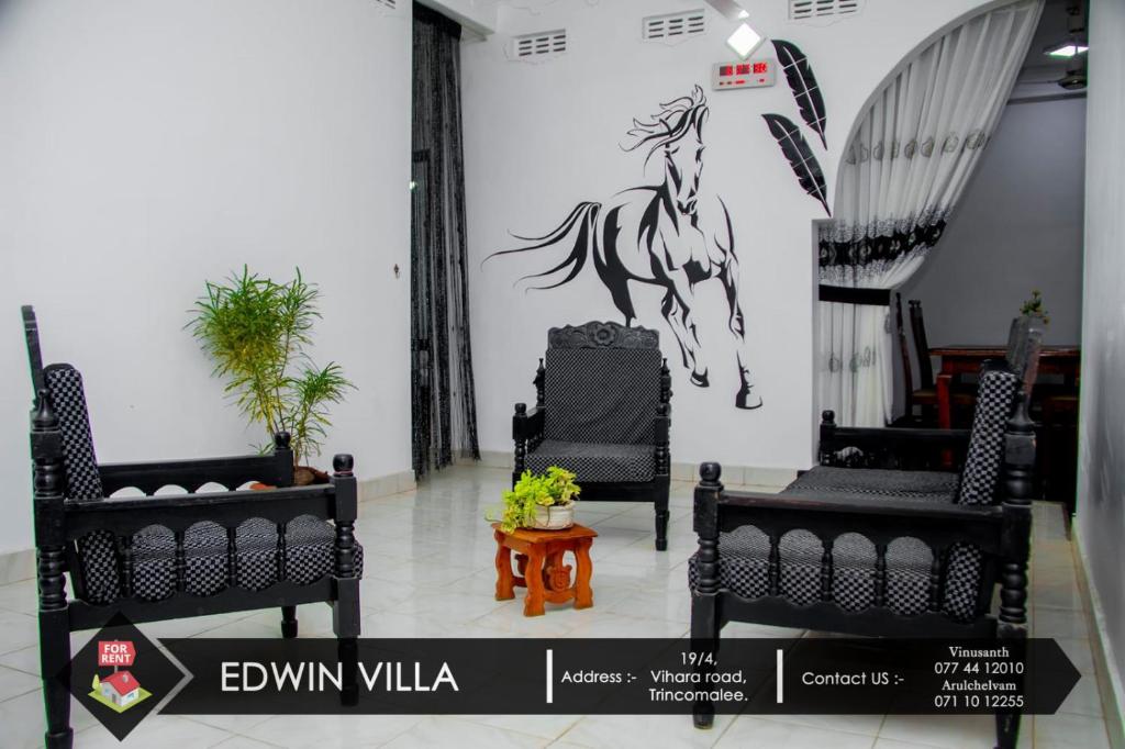 a room with two chairs and a horse stencil on the wall at Edwin Villa in Trincomalee