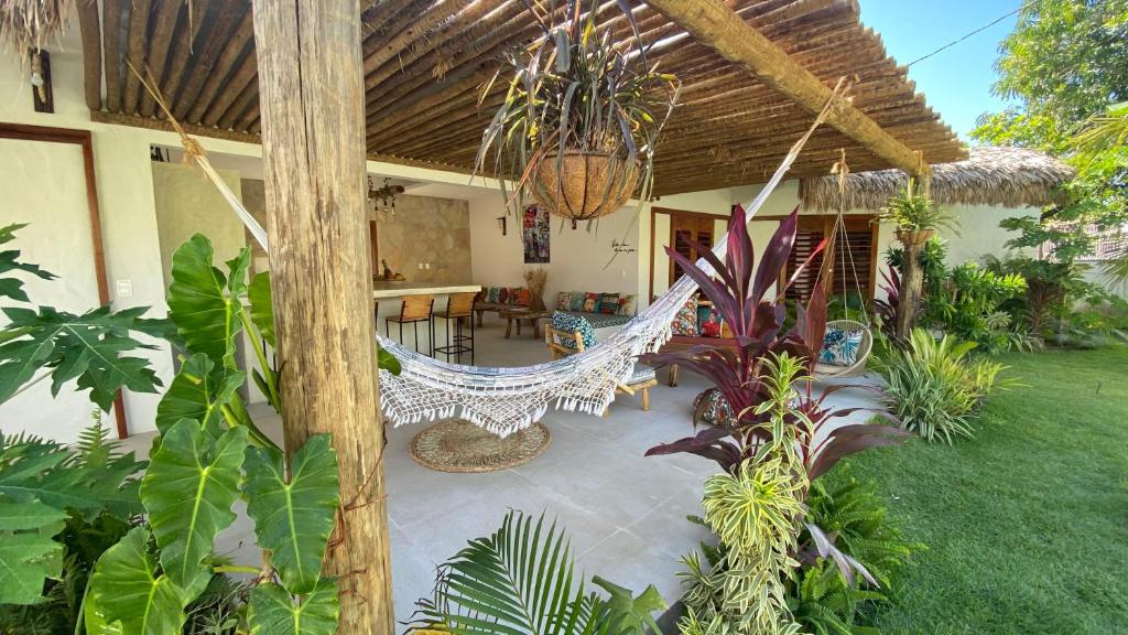 a porch with a hammock on a house with plants at Casa Pura Vida - Icaraizinho in Icaraí
