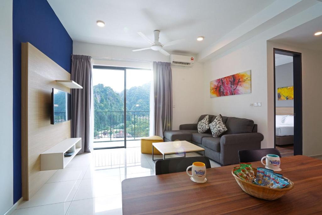 a living room with a table and a couch at Sunway Onsen Hospitality Suites in Ipoh