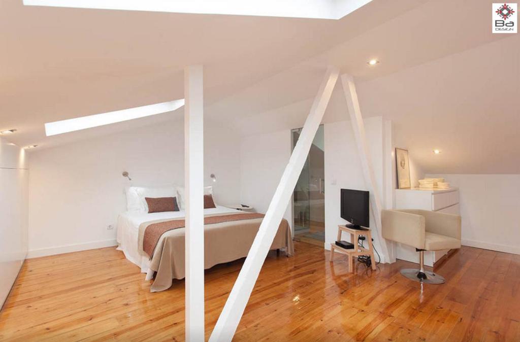 リスボンにあるデザイン デュプレックス アパートメント BA / シアードのベッドルーム(ベッド1台、デスク、テレビ付)