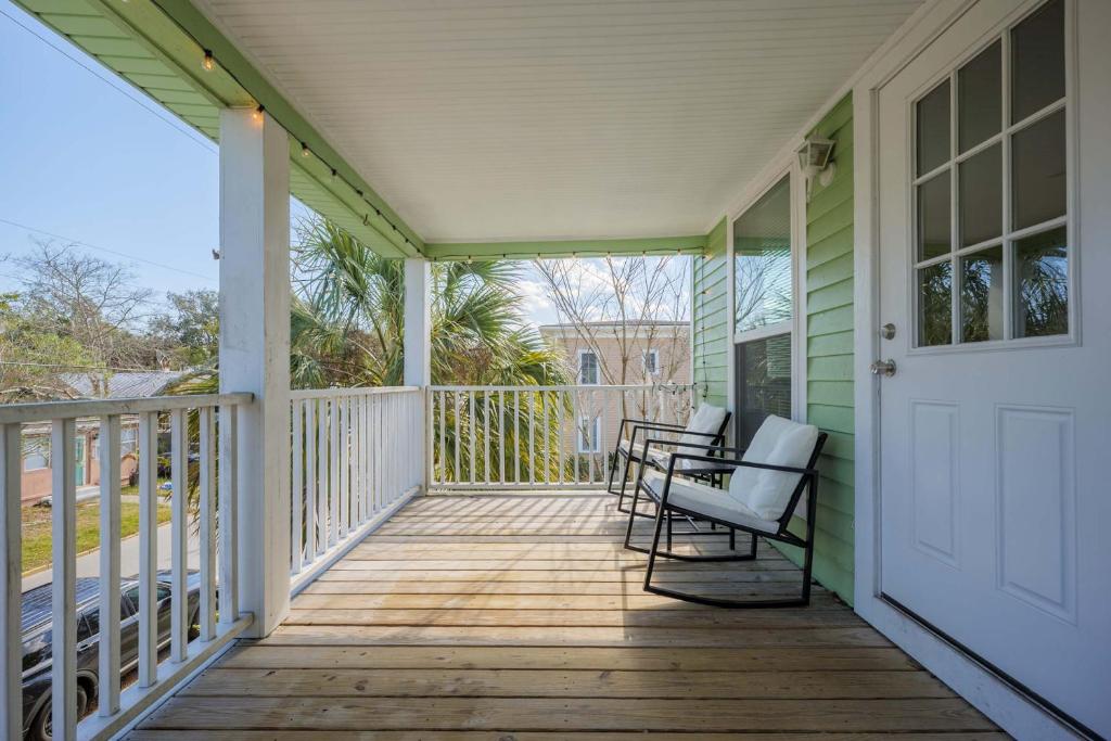 a porch with a white door and chairs on it at Cordova Dream Upper in St. Augustine