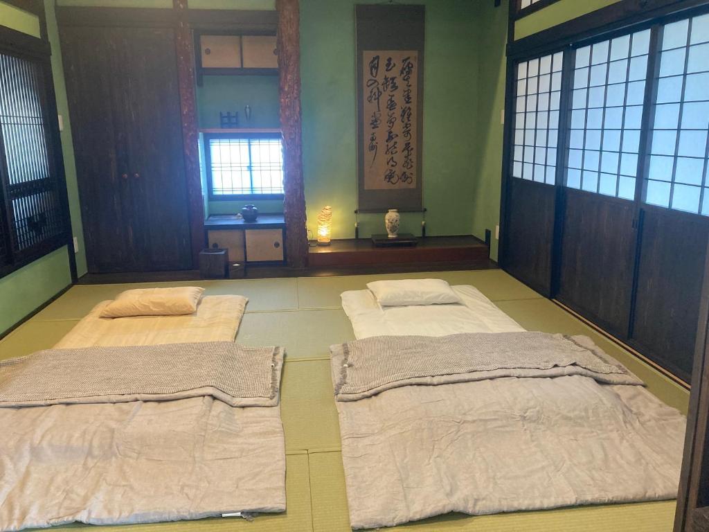 奄美市にあるゲストハウスナゼのベッド2台が備わる客室です。