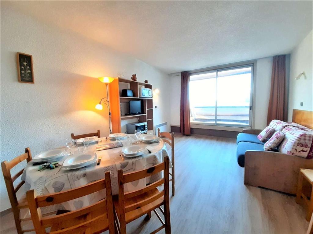 a living room with a table and a couch at Studio cabine 6 pers avec balcon et vue sur pistes - FR-1-457-202 in Aragnouet