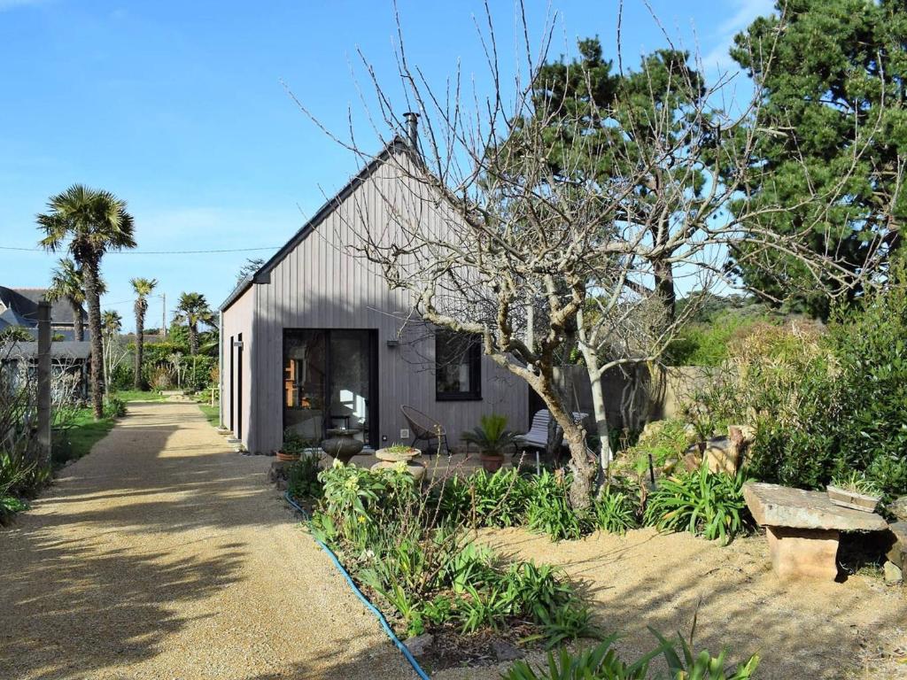 un petit hangar blanc avec un arbre en face dans l'établissement Maison neuve avec jardin à 150m de la mer à Trégastel, proche port et plage - FR-1-368-145, à Trégastel