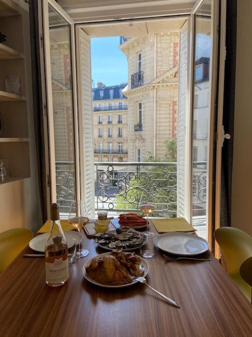 - une table avec une assiette de nourriture et une bouteille de vin dans l'établissement Coeur de Montorgueil angle Tiquetonne ensoleillé, à Paris