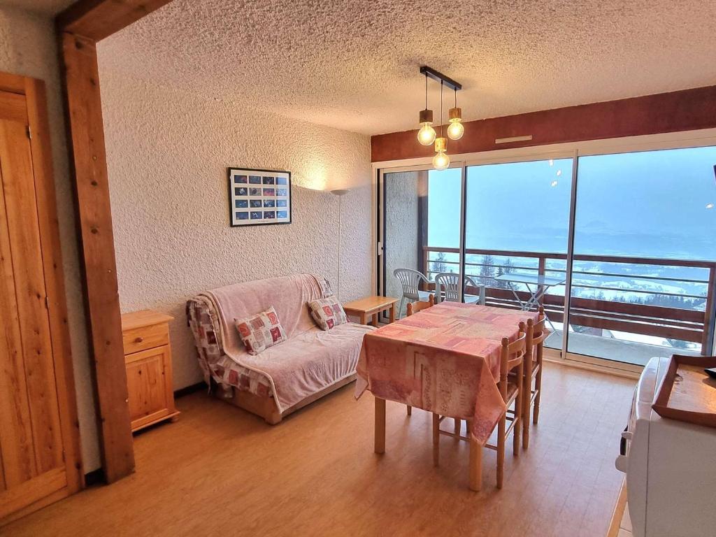 - un salon avec une table et une vue sur l'océan dans l'établissement Appartement 4 pers, balcon sud, parking, wifi, animaux admis - FR-1-393-3, à Saint-Michel-de-Chaillol