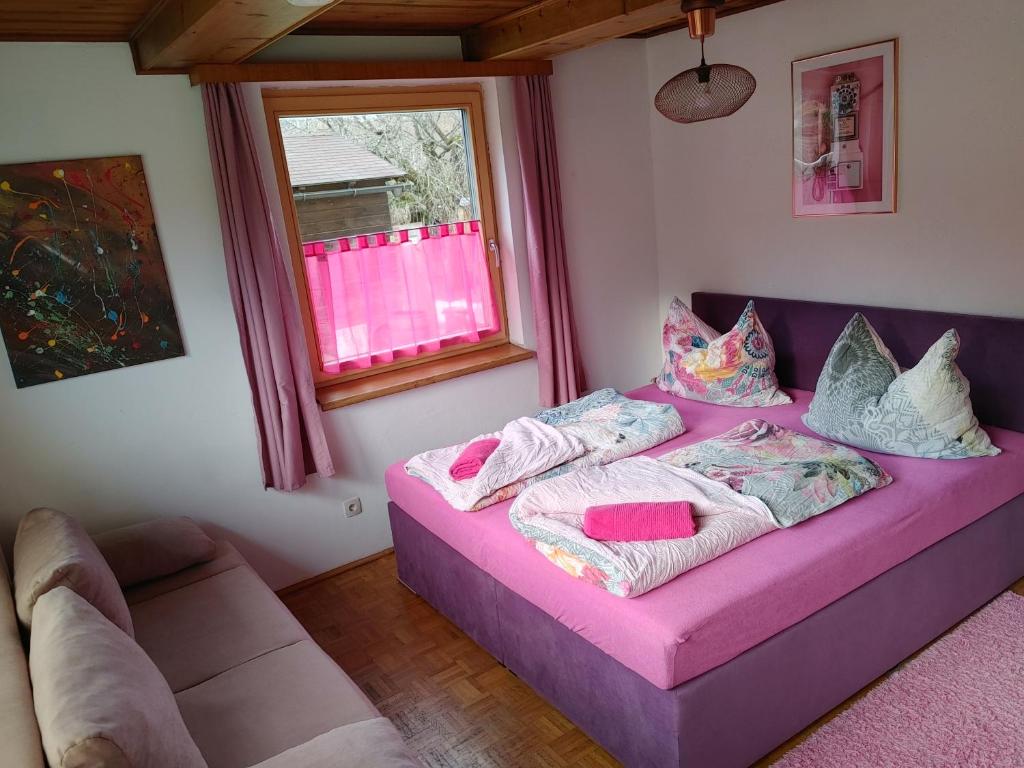 um sofá roxo numa sala de estar com uma janela em Appartement Mary em Schladming