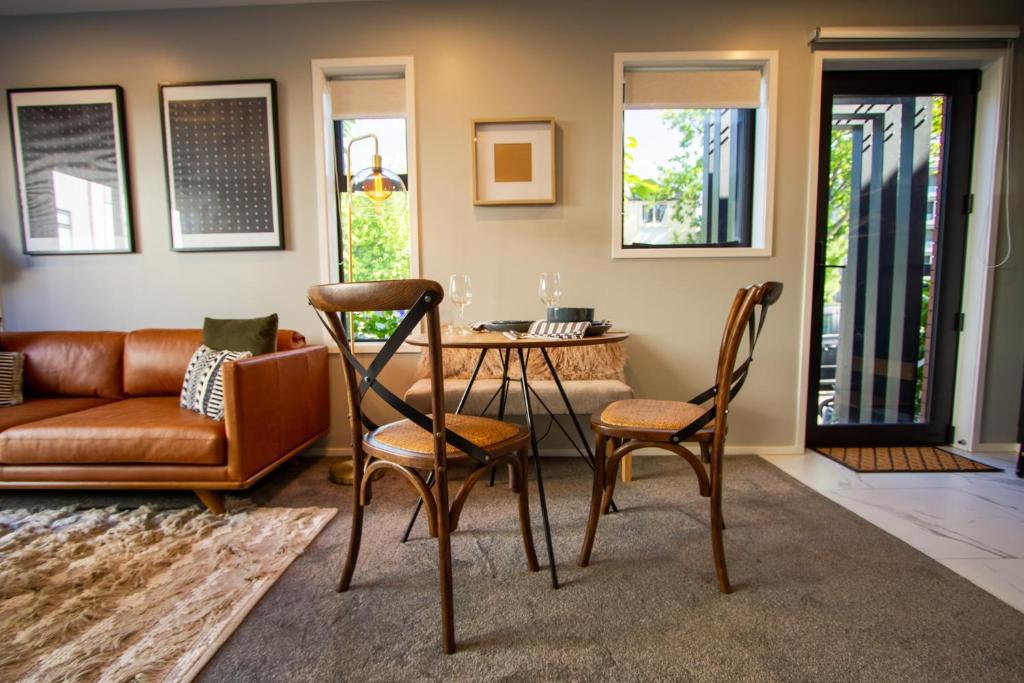 a living room with a couch and a table and chairs at New Boutique Central Sanctuary near Latimer Square in Christchurch