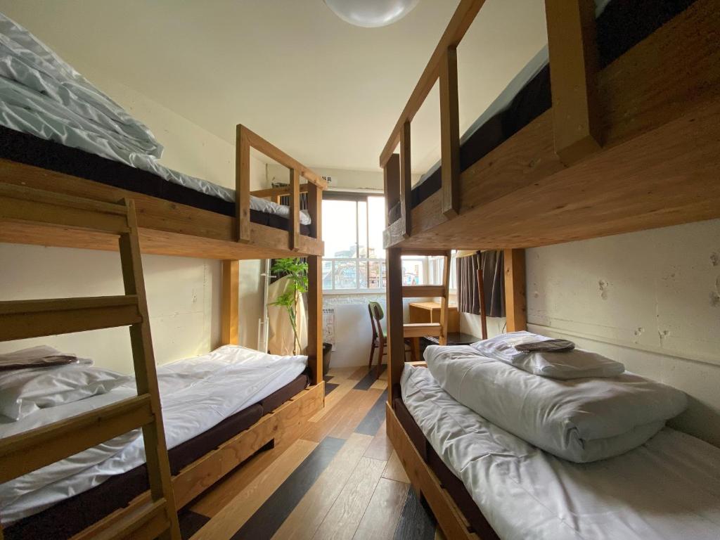 東京にあるSTAY WORK ASAKUSA guest house 浅草店の二段ベッドが2つと窓のある部屋