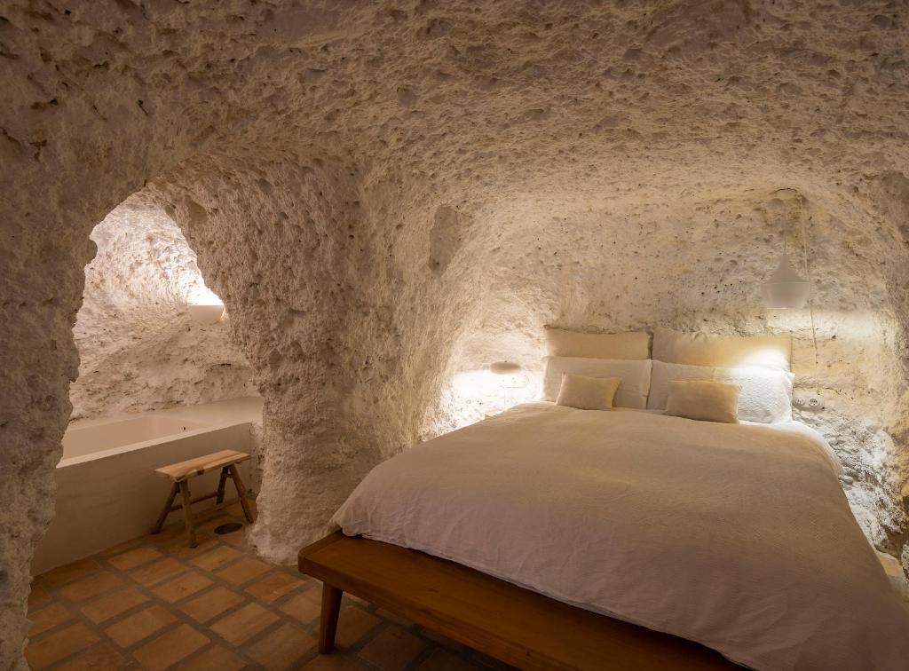 1 dormitorio con 1 cama en una pared de piedra en Carmen del Azahar by Florentia Homes, en Granada
