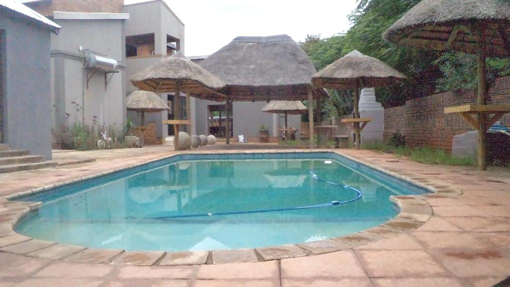 a swimming pool in front of a house at Kadichueni Guest House in Zeerust