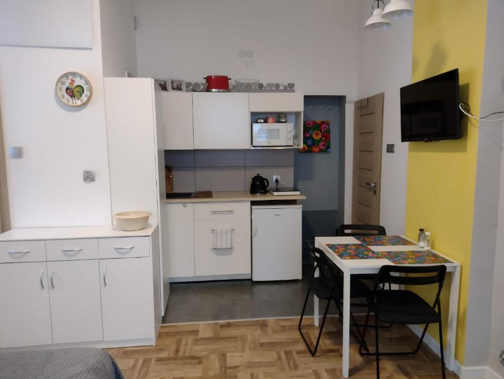 a kitchen with white cabinets and a table with chairs at Krokus in Sokołowsko