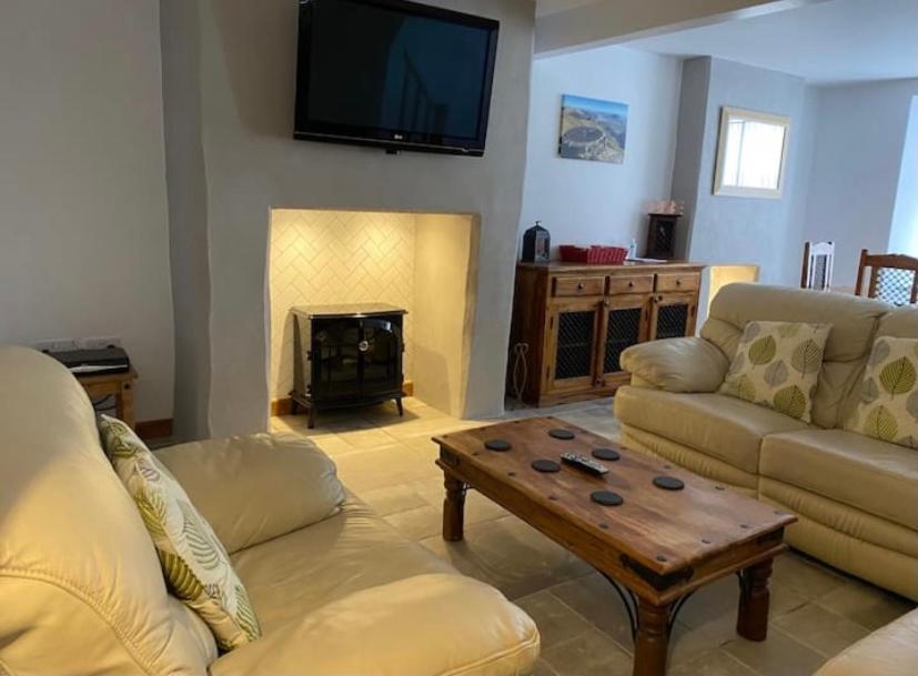 a living room with a couch and a coffee table at Tegfan Victorian terrace Cottage Snowdonia Llanberis in Llanberis