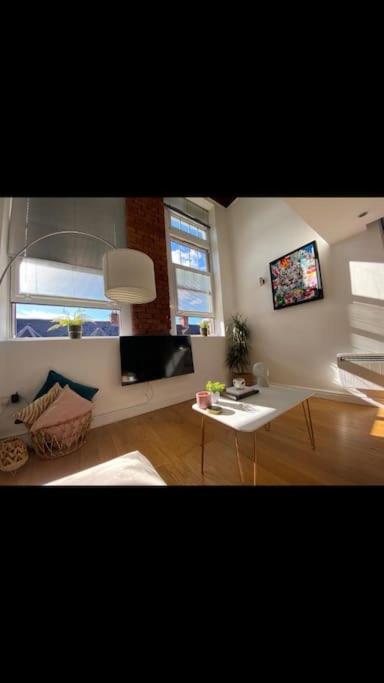 a living room with a table and a window at Lovely 1-Bedroom loft apartment in Cardiff