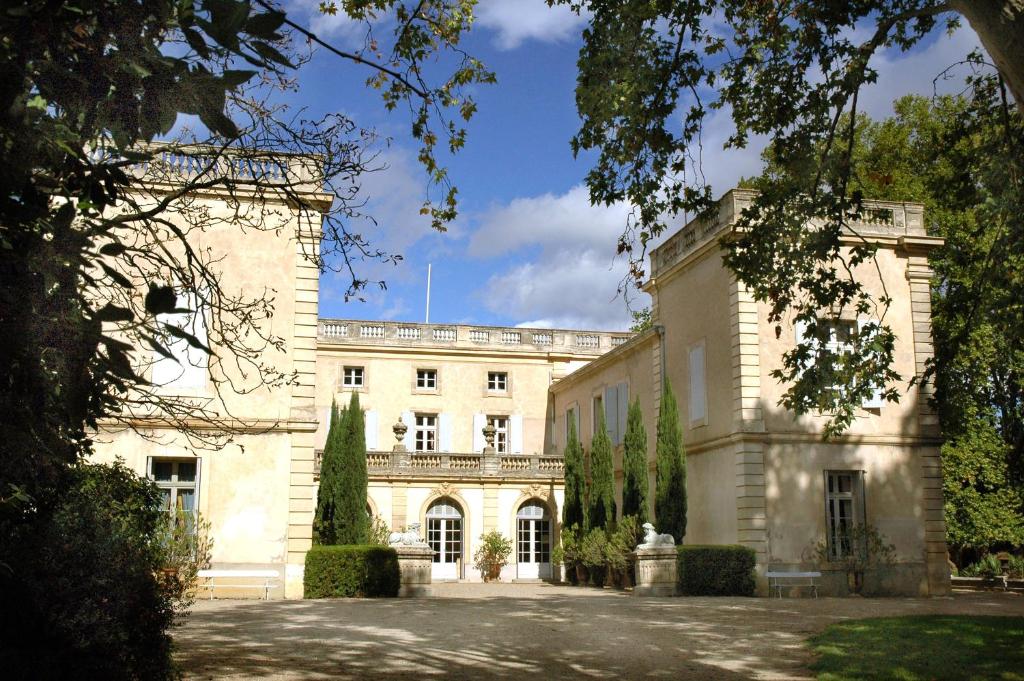 - un grand bâtiment blanc avec un balcon dans l'établissement Chateau de Raissac, à Béziers