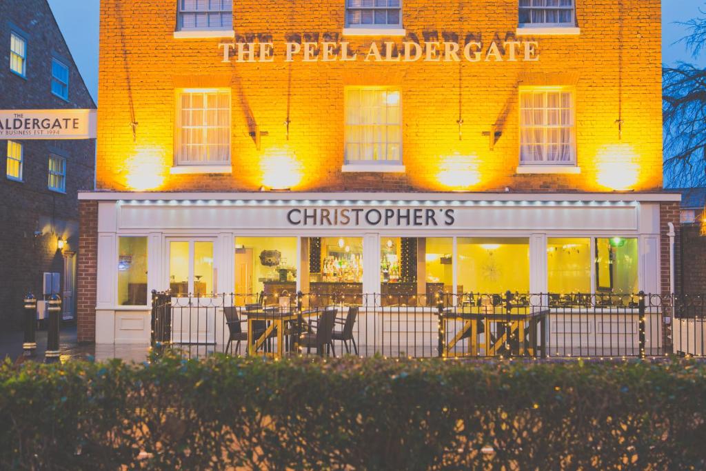 um restaurante com mesas e cadeiras em frente a um edifício em The Peel Aldergate em Tamworth