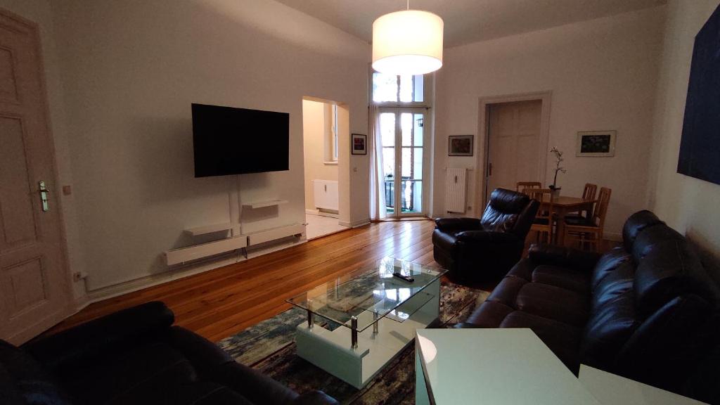 uma sala de estar com sofás e uma televisão de ecrã plano em Ferienwohnung Cottbuser City em Cottbus