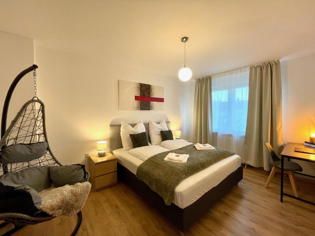 ein Schlafzimmer mit einem Bett, einem Stuhl und einem Fenster in der Unterkunft Downtown Apartment by NINJA SPACES - Kingsize-Bett, Küche, Netflix, Terrasse in Wuppertal