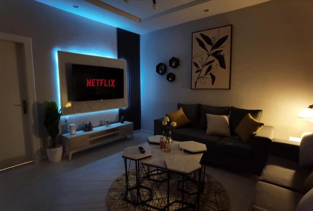 شقة هادئة في موقع مميز ودخول ذاتي في حي الصحافة في الرياض: غرفة معيشة مع أريكة وتلفزيون