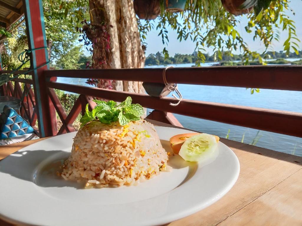 un plato blanco de comida con arroz en una mesa en Mr.Bounhome Guesthouse and restaurant en Muang Không