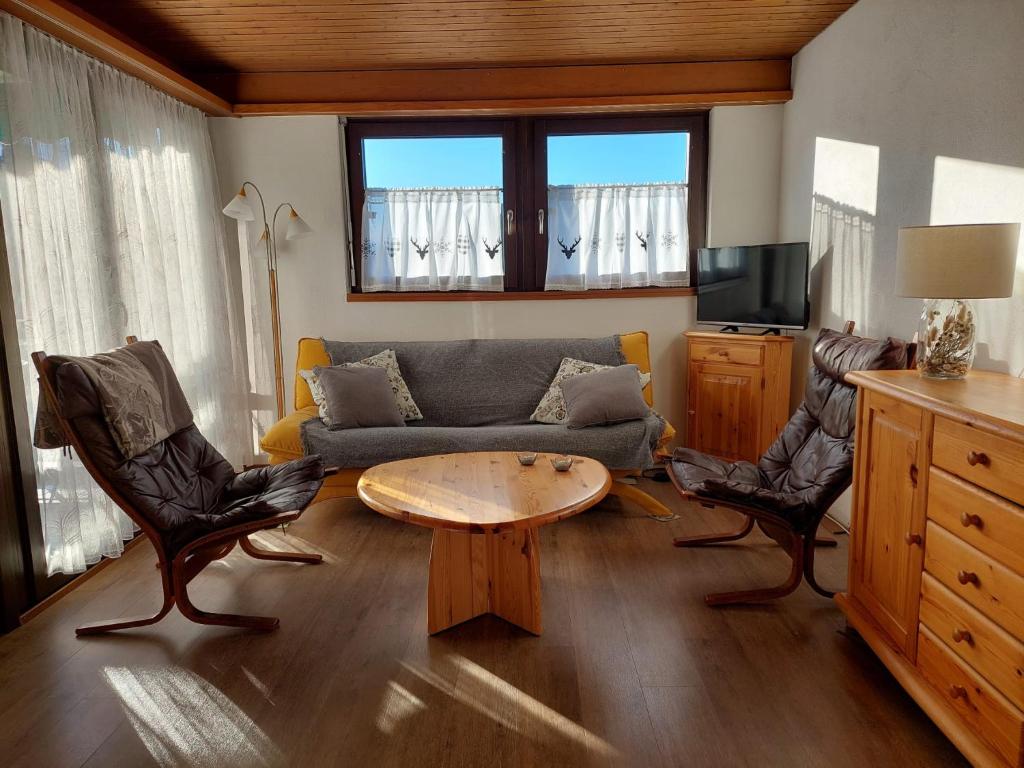 sala de estar con sofá, mesa y sillas en Ferien in der Region Lenzerheide, en Lenz