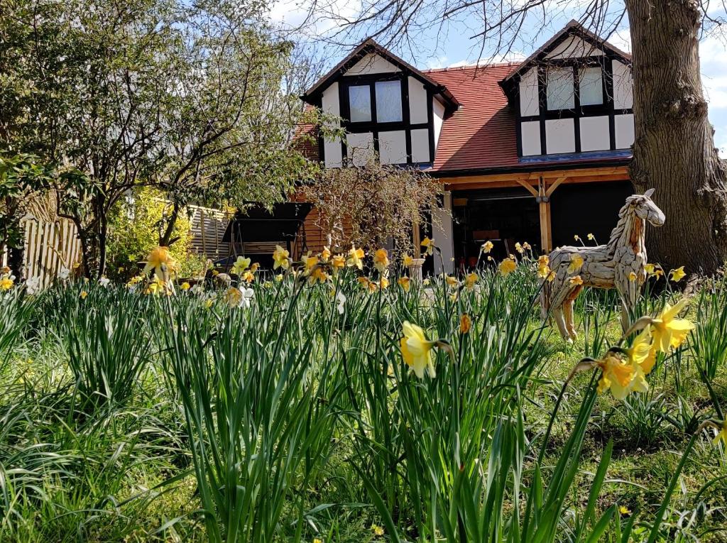 una casa con flores amarillas delante de ella en Delightful & Picturesque Modern Detached Apartment, Next to Chester Zoo, Near Park and Ride to City Centre, en Chester