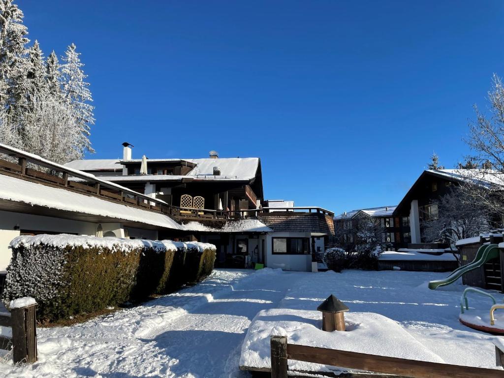 a snow covered yard with a house in the background at Appartementanlage Kerber in Seefeld in Tirol