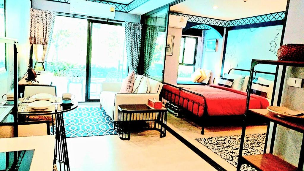 una camera con letto rosso e un soggiorno di New. Beautiful One Bedroom Pool Access Condo. Only 200 metres to the beach. a Hua Hin