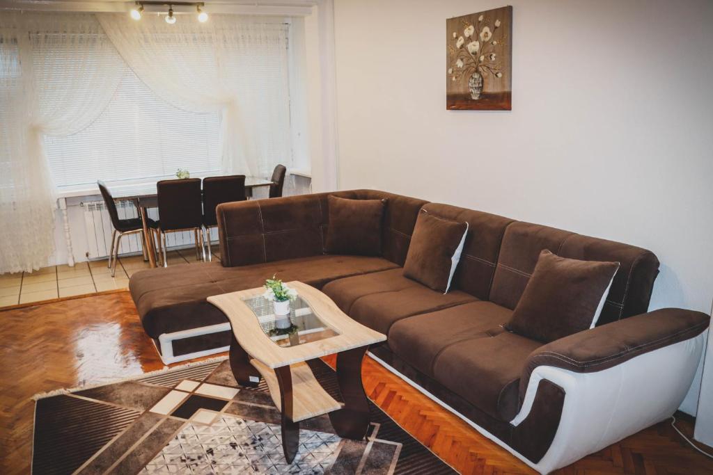 a living room with a brown couch and a table at 3 Rooms, Loft Apartment, Located RIGHT in CENTER!!! in Razgrad