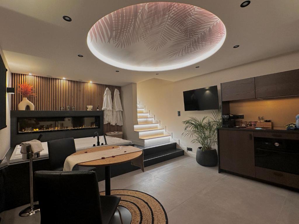 ein Wohnzimmer mit einem Tisch und einer großen Leuchte in der Unterkunft Maison Nina, Suite d’exception in Villeneuve-la-Garenne