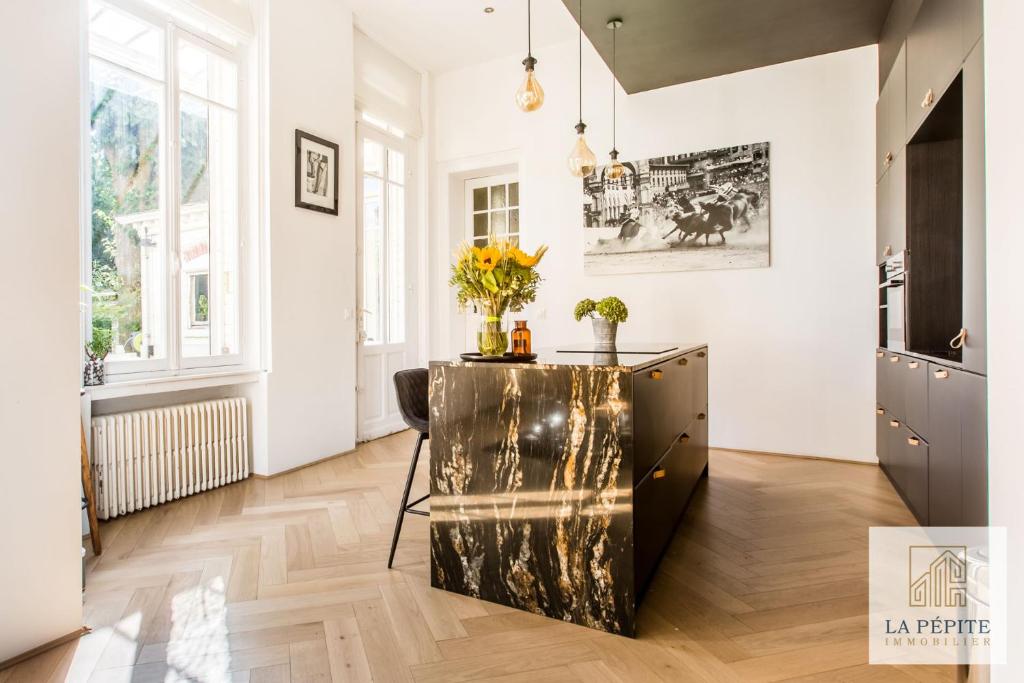 una cocina con una mesa con flores. en Hôtel particulier - Le 119, en Valenciennes