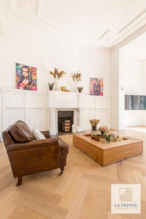 sala de estar con sofá y chimenea en Hôtel particulier - Le 119, en Valenciennes