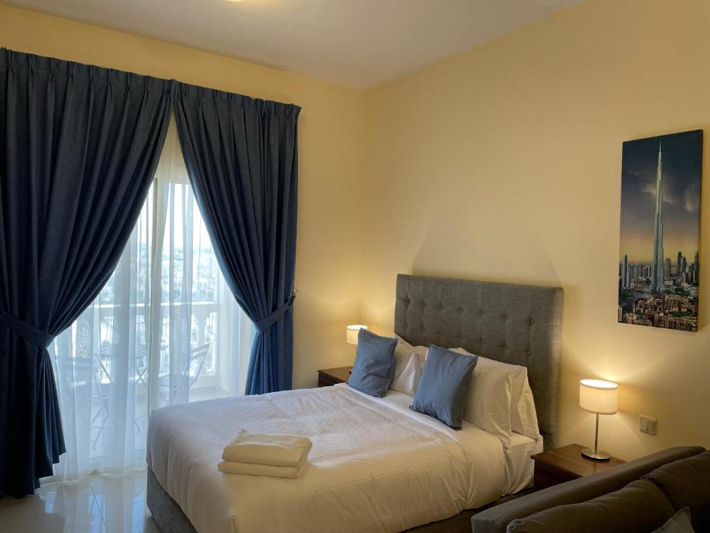 a bedroom with a bed and a large window at Studio Apartment - Royal Breeze 05 in Ras al Khaimah