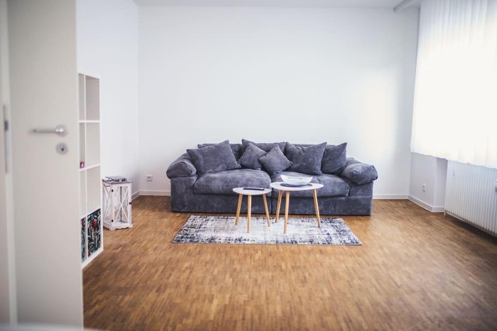 a living room with a couch and two tables at Wunderschöne neue 3,5 Zimmerwohnung Nähe Kassel bis 4 Erwachsene 3 Kinder in Fuldatal