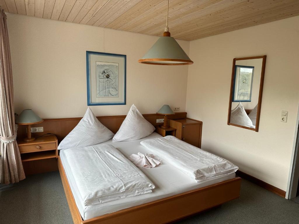 a bedroom with a bed with white sheets at Mike‘s Mosel Lodge in Treis-Karden