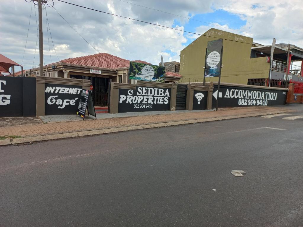 a person walking down a street next to a building at sediba guest house in Krugersdorp