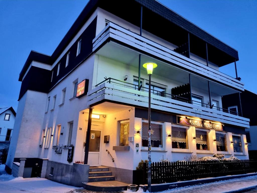 a white building with a street light in front of it at Sevda's Hotel Garni Weinforth in Willingen