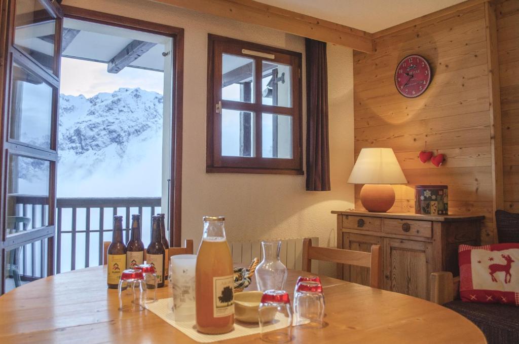 - une salle à manger avec une table et des bouteilles de vin dans l'établissement Granges 32 - Beau Duplex spacieux, au pied des pistes Domaine Alpe d'Huez, à Villard-Reculas