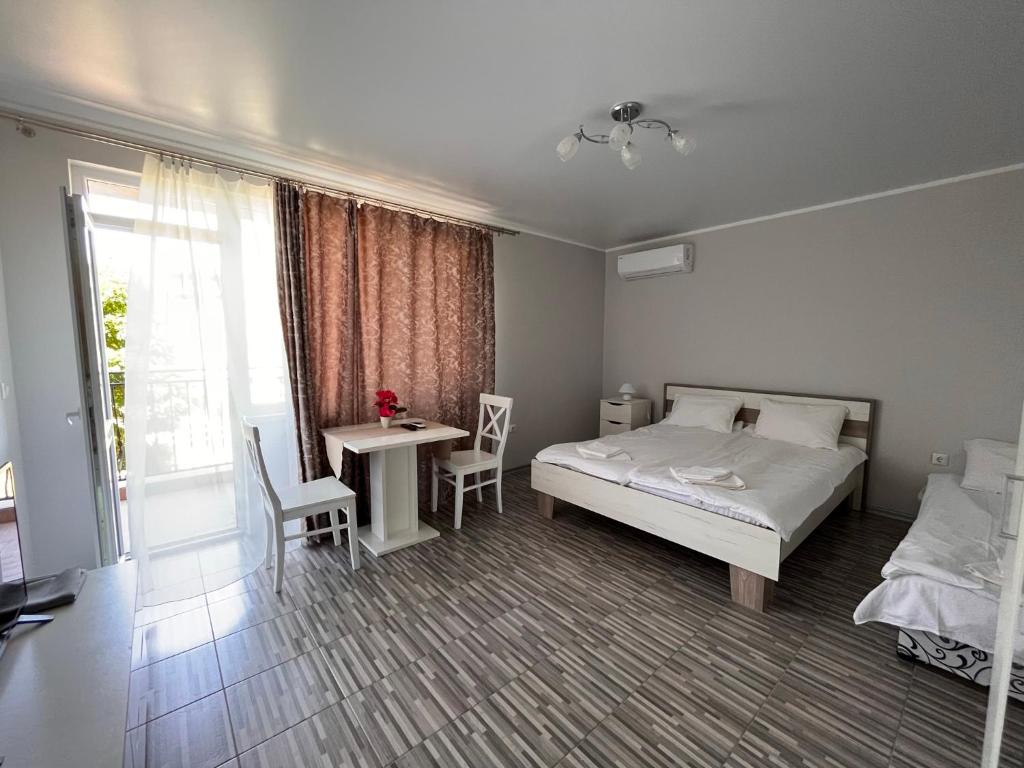 a bedroom with a bed and a table and chairs at Studio SeaDream in Primorsko