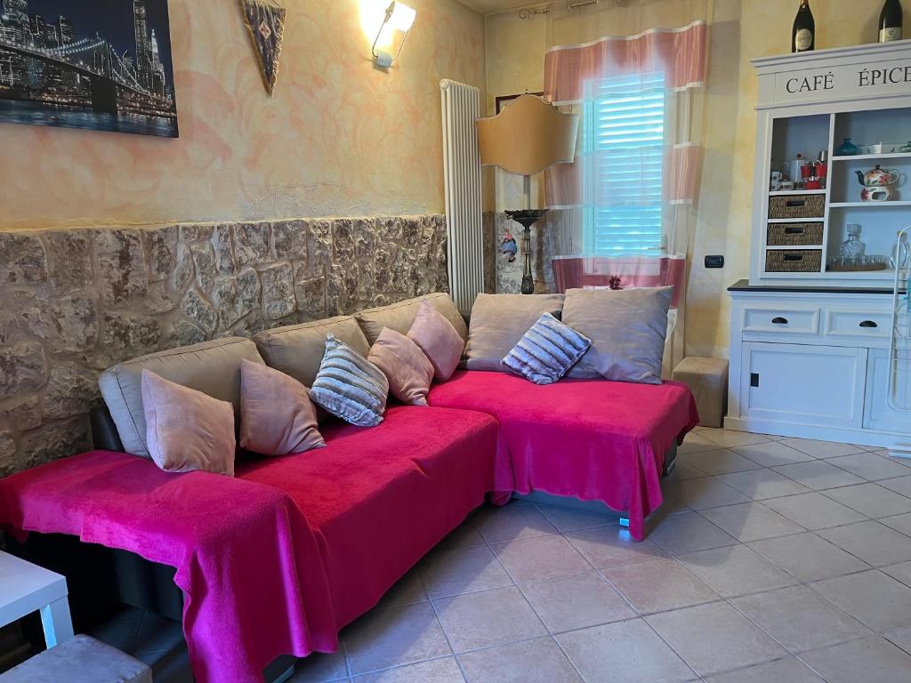 um sofá com almofadas cor-de-rosa numa sala de estar em Perfetto relax em Arena Metato