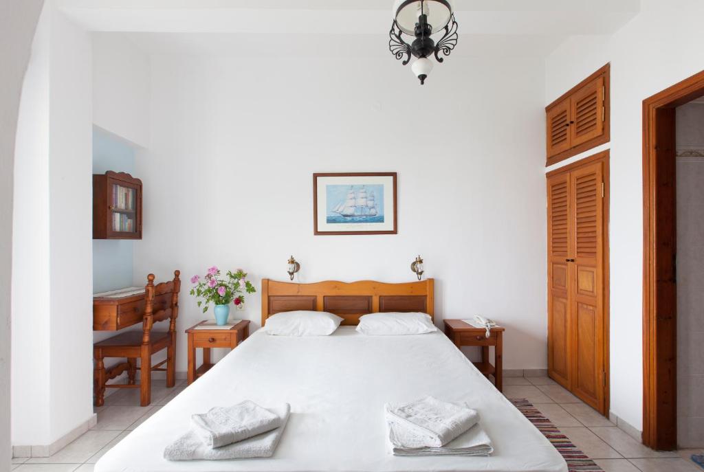 a bedroom with a large white bed in a room at DELFINI I in Fira