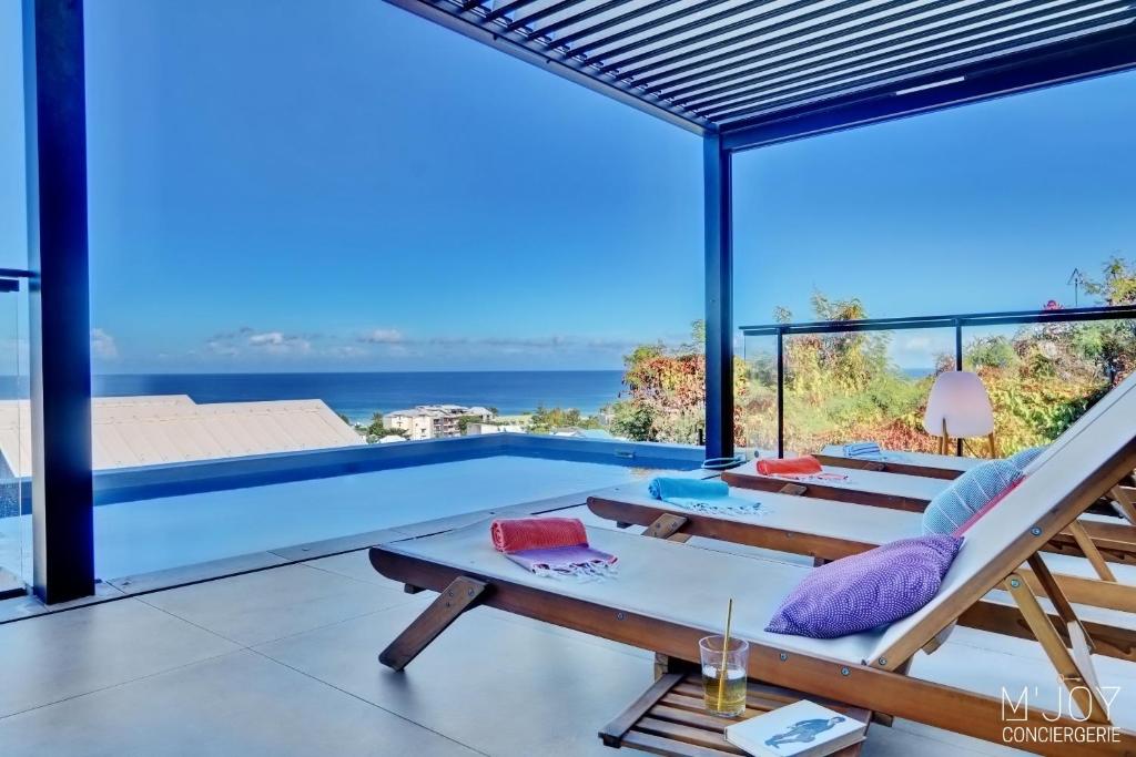 uma villa com uma piscina e uma varanda em Villa Azur Saint-Gilles - La Réunion - Seaview, Pool, Beach & BBQ! em Saint-Gilles-les-Bains